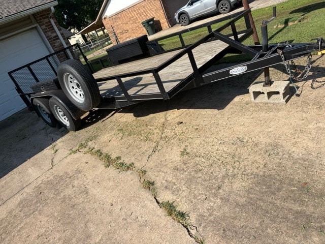 Precision utility trailer — low angle side view showing dual axles and Precision logo